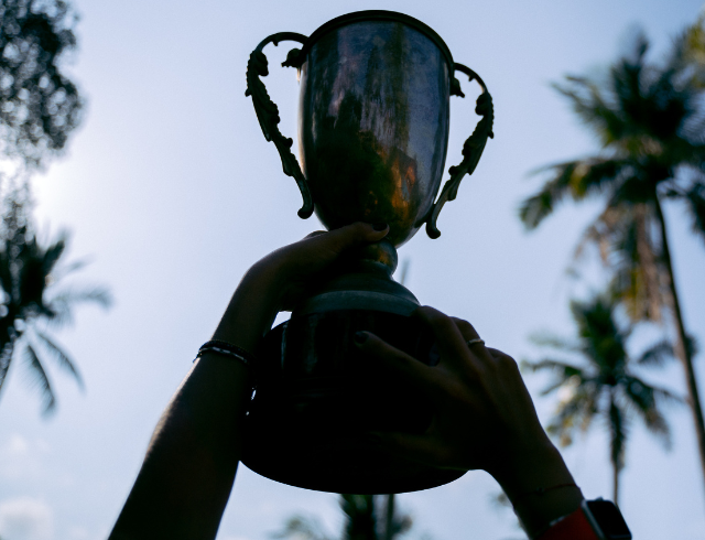 cropped hand of athlete holding trophy in the air