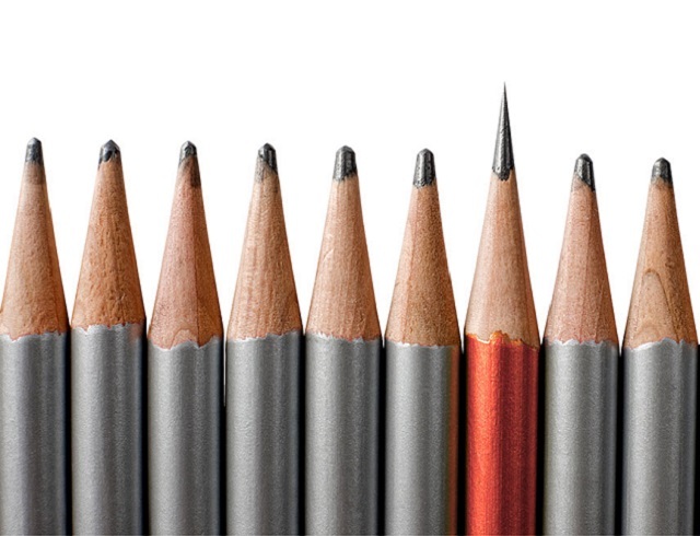 Several silver pencils with one orange one more sharpened